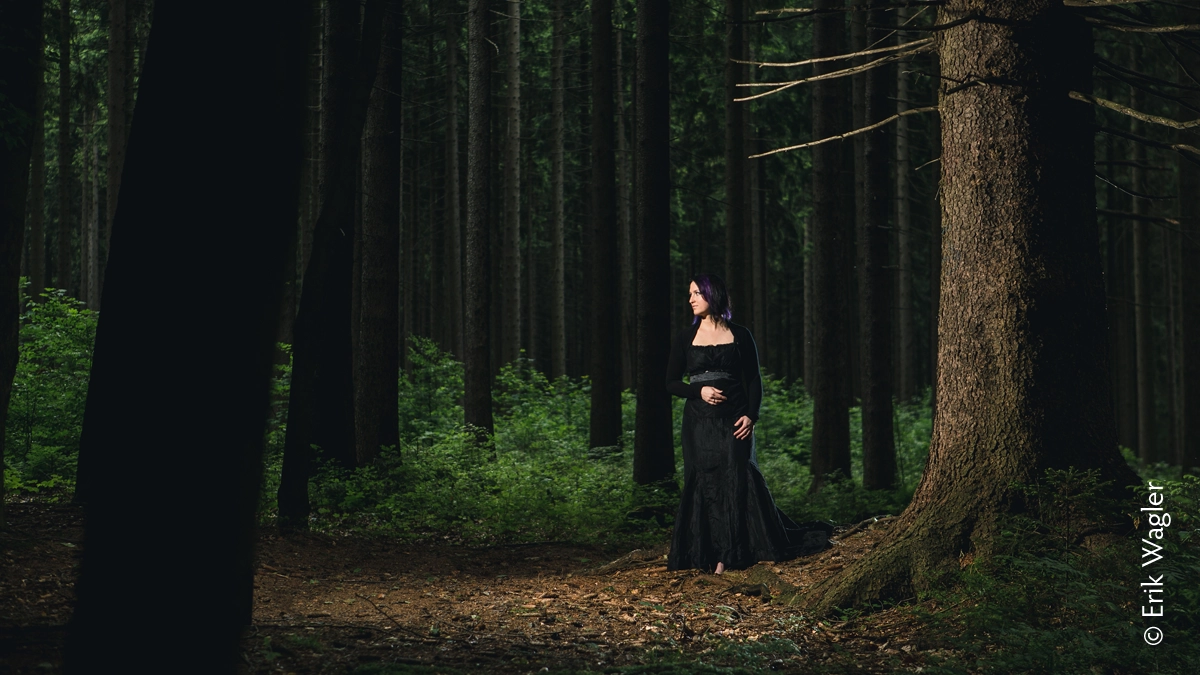 Luise Egermann steht in einem dunklen Wald